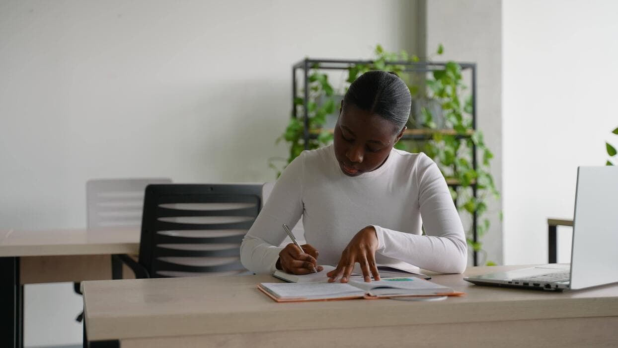 Une apprenante concentrée écrit dans son cahier